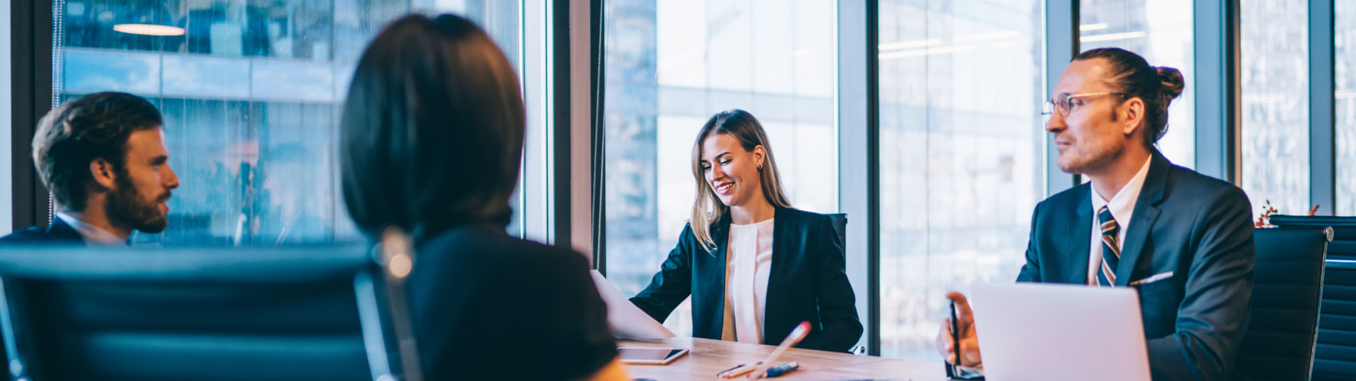 A group of young businesspeople sitting around a board table.