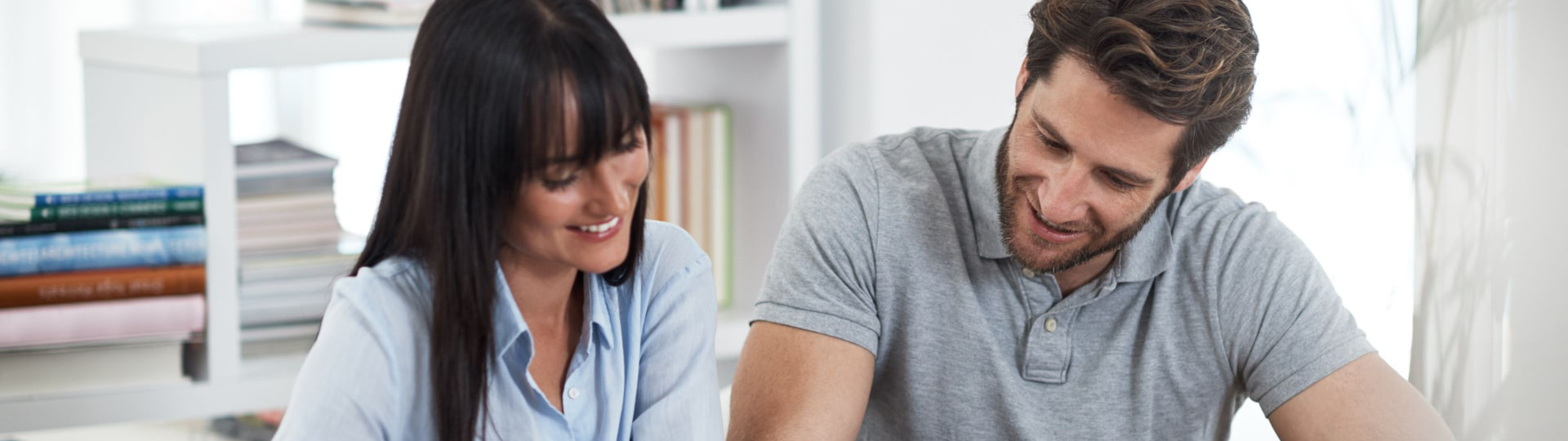A woman and man smiling while going over information.